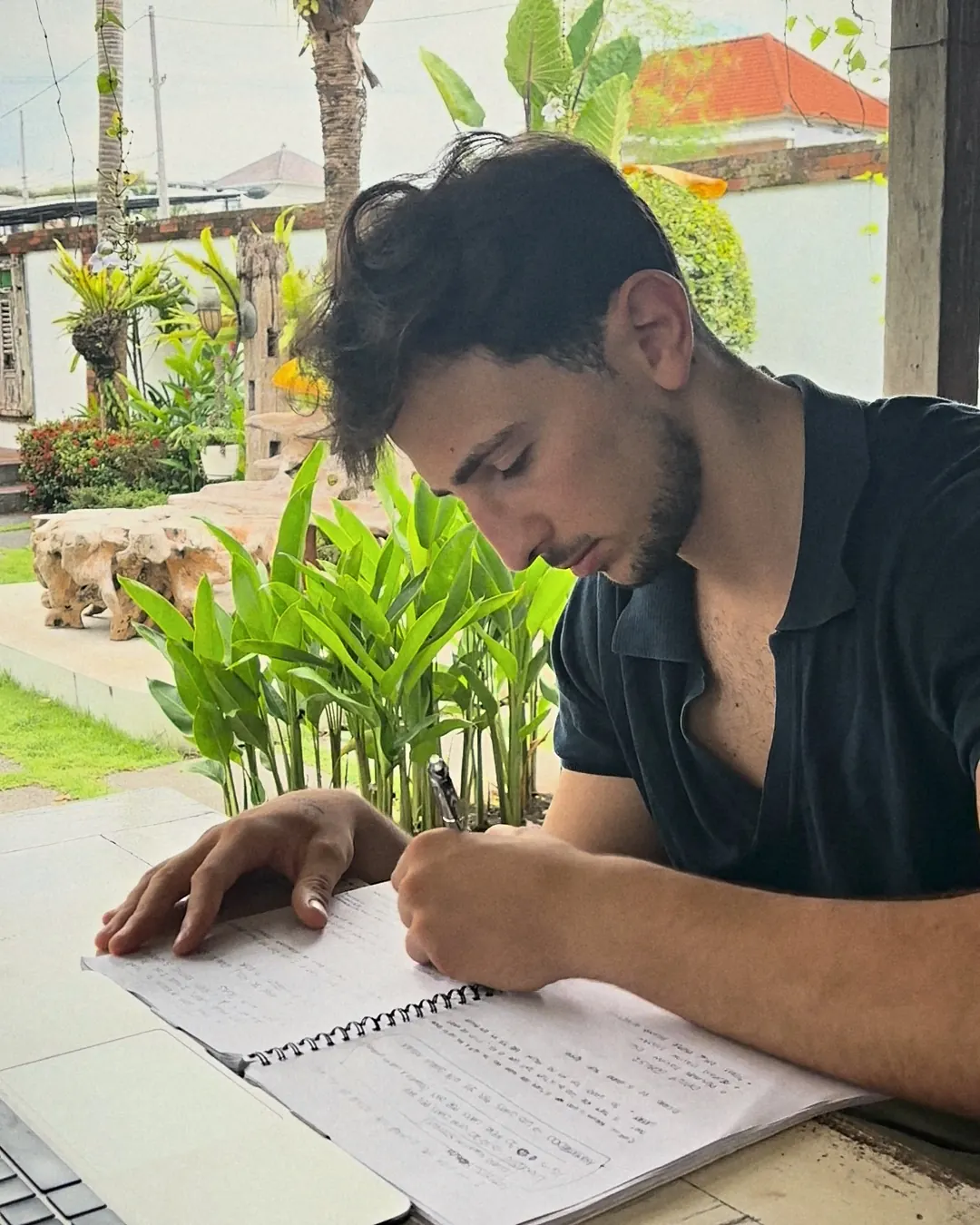 Francescomatteo scrive su un quaderno in terrazza